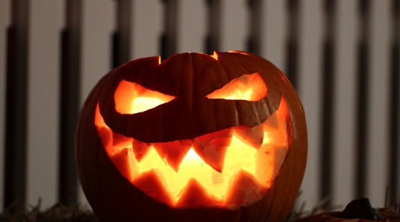 Lit-up Jack-o-lantern pumpkin with wide mouth and sharp teeth